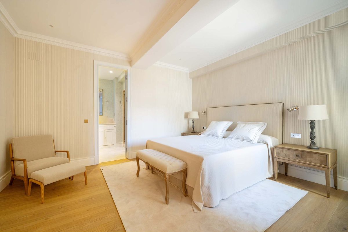 Dormitorio principal con banco a los pies de la cama